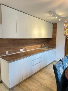 a kitchen with white cabinets and a sink at Casa Horeb Apuseni in Sohodol +13 photos