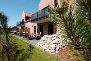 a brick house with a patio with a table and chairs at Küsten Suite Nord - direkte Wasserlage, Terrasse, 70qm in Greetsiel