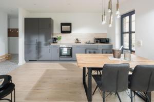 a kitchen with a wooden table and a dining room at Küsten Suite Nord - direkte Wasserlage, Terrasse, 70qm in Greetsiel