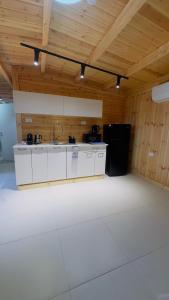 a kitchen with a sink and a black refrigerator at צימרים שדות אור in Maʼor