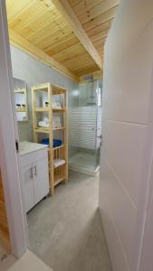 a bathroom with white cabinets and a glass shower at צימרים שדות אור in Maʼor