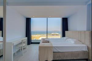 a bedroom with a bed and a desk and a view of the ocean at FOR LARGE FAMILIES, DUPLEX Vılla-304 in Çeşme +16 photos