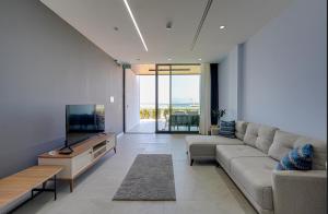 a living room with a couch and a flat screen tv at FOR LARGE FAMILIES, DUPLEX Vılla-304 in Çeşme