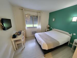 a small bedroom with a bed and a television at Logis Hôtel Restaurant Chez Nous in Sainte-Croix