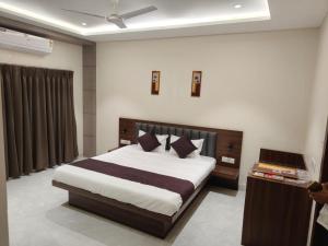 a bedroom with a large bed in a room at Hotel Bhasmaarti Ujjain in Ujjain