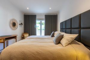 a bedroom with a large bed with a large headboard at Pine Tree Seaside Apartments 500m to Beach in Albufeira +63 photos