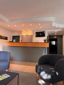 a living room with a couch and a bar with a tv at Hobbit Hotel Brussels Airport Zaventem in Zaventem