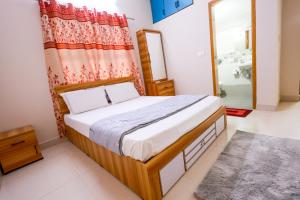 a bedroom with a bed and a mirror and a shower at Aranya Ocean Breeze in Mangalore
