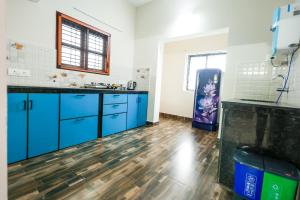 a kitchen with blue cabinets and a blue refrigerator at Aranya Ocean Breeze in Mangalore