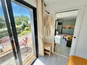 a sliding glass door to a balcony with a suit hanging on it at Maison des Chênes 64 - Spa Lodge in Boucau