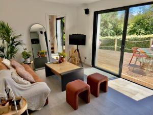 a living room with a couch and a table at Maison des Chênes 64 - Spa Lodge in Boucau
