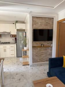 a living room with a tv on a brick wall at Armonia buglaow residence MARSA MDIQ in M'diq +12 photos