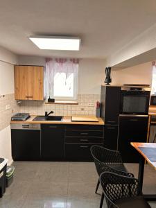 a kitchen with black appliances and a table and chairs at Fe Wo auf der Alb in Wittlingen