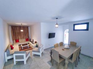 a dining room with a table and chairs and a living room at Dar Bourri in Al Matlīn