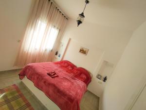 a bedroom with a bed with a red blanket on it at Dar Bourri in Al Matlīn +13 photos
