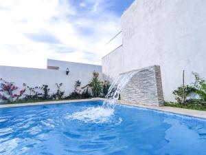 a pool with a water fountain in front of a building at Dar Bourri in Al Matlīn