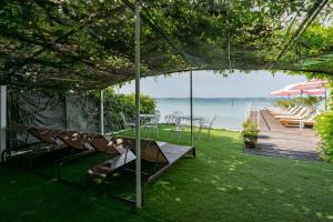 a backyard with chairs and a table and a view of the ocean at Hotel Serenella in Sirmione