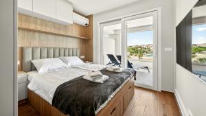a bedroom with a large bed and a balcony at Smile Apartments in Povljana +37 photos
