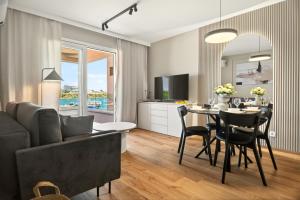 a living room with a couch and a table with chairs at Smile Apartments in Povljana