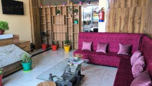 a living room with a purple couch and a table at Hill Mountain Hotel in Chakarpur