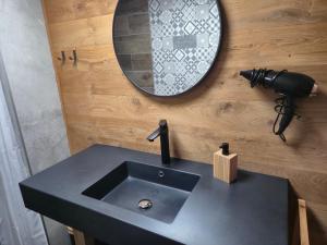 a bathroom with a black sink and a mirror at Gîte L'Aventura in Vielsalm