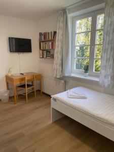 a bedroom with a bed and a desk and a window at VITA Ferienresidenz in Neu Kaliß