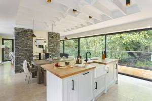 a kitchen with white cabinets and a large window at Fawns Keep - Ridgestone in Bowland Bridge