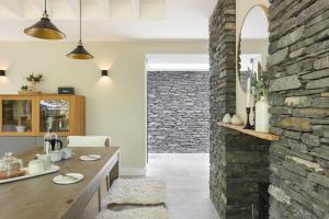 a kitchen with a stone wall and a wooden table at Fawns Keep - Ridgestone in Bowland Bridge +42 photos