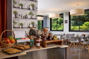 a breakfast buffet in a restaurant with food on a counter at Zenitude Swiss Apparthotels in Ferney-Voltaire