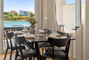 a dining room with a table and chairs and a window at Smile Apartments in Povljana