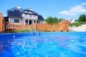 a swimming pool in front of a house at Dwór Meluzyna in Janowiec