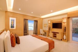 a bedroom with a large bed and a television at Lemon Tree Premier, Delhi Airport in New Delhi