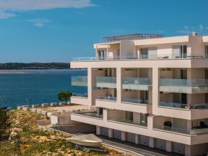 an apartment building with the ocean in the background at Smile Apartments in Povljana
