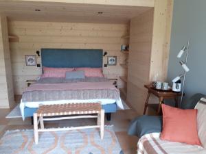 a bedroom with a large bed and a couch at Le chalet du Chardonneret in Soultzbach-les-Bains