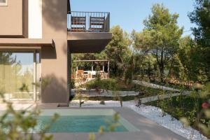 a house with a swimming pool and a garden at Domus Gaia Suites in Nikiti