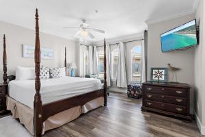 a bedroom with a bed and a flat screen tv at The Blue Lagoon in Rosemary Beach +60 photos