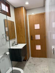 a bathroom with a toilet and a sink and a door at Armonia buglaow residence MARSA MDIQ in M'diq