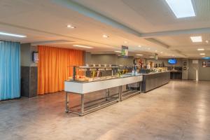 a buffet line in a mall with an orange curtain at a&o München Hackerbrücke in Munich