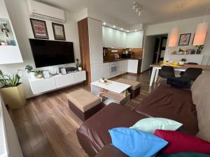 a living room with a couch and a tv at Apartament Crooked stairs in Zielona Góra