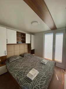 a bedroom with a bed with two towels on it at Floating house Sunflower in Pula