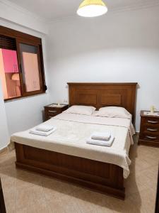 a bedroom with a bed with two towels on it at Terminal Comfort Apartament in Tirana