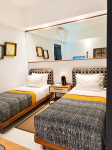 a bedroom with two beds and a table with a night stand at Kosenda Hotel in Jakarta