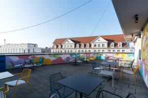 a patio with tables and chairs and a building at a&o München Hackerbrücke in Munich