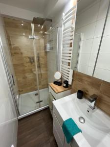 a bathroom with a white sink and a shower at Apartament Crooked stairs in Zielona Góra