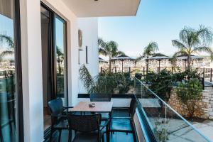 a patio with a table and chairs on a balcony at Ori Mare Hotel in Ksamil