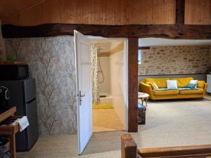 a living room with a yellow couch in a room at Domaine de la Bréssandière in Châtillon-sur-Thouet