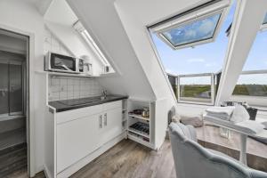 a kitchen with white cabinets and a window at Gurtdeel 1000 Sterne-Suite in Hörnum