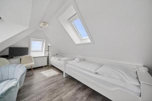 a white bedroom with a bed and a desk at Gurtdeel 1000 Sterne-Suite in Hörnum