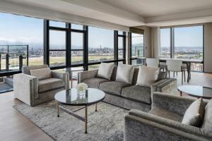 a living room with couches and tables and large windows at Taipei Marriott Hotel in Taipei