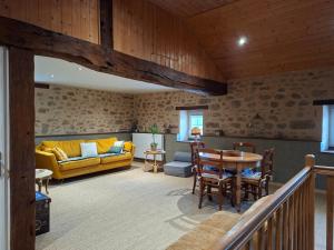 a living room with a yellow couch and a table at Domaine de la Bréssandière in Châtillon-sur-Thouet
